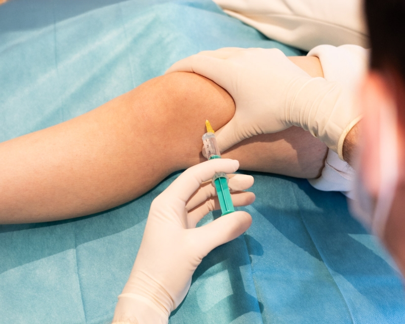 Eine Spritze wird in ein Kniegelenk gesetzt